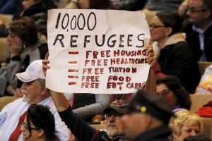 An audience member holds up an anti-refugee sign during a campaign rally with U.S. Republican presidential candidate Donald Trump in Worcester