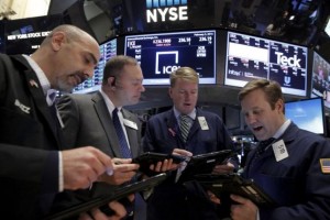 Traders work with a floor official on the floor of the NYSE
